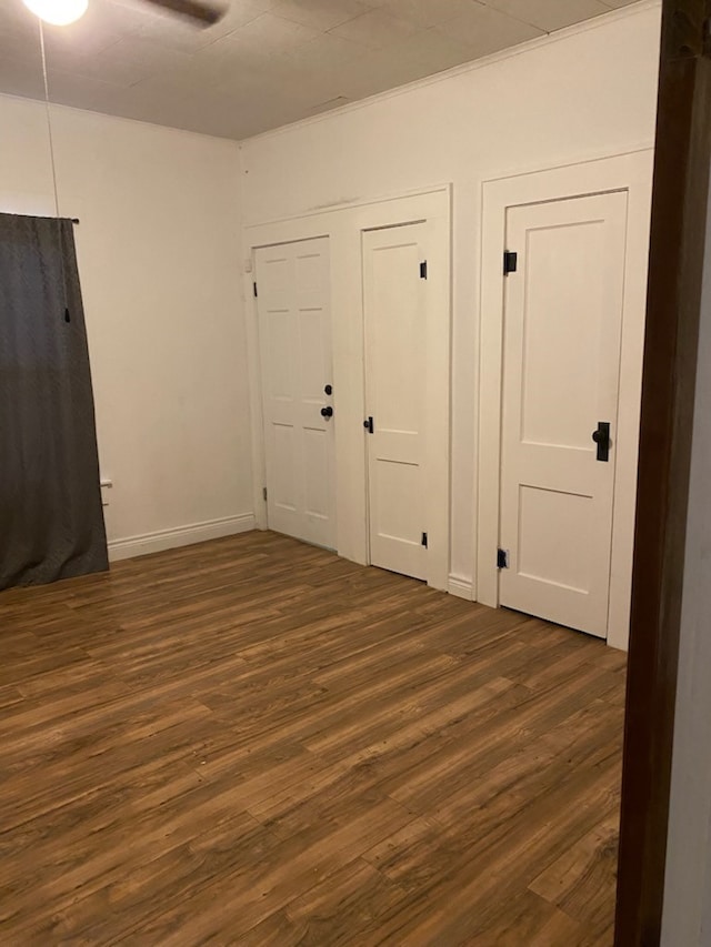 unfurnished bedroom with dark wood finished floors