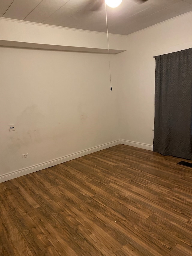 unfurnished room featuring dark wood-style floors, visible vents, and baseboards