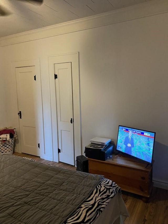 bedroom featuring ornamental molding and wood finished floors