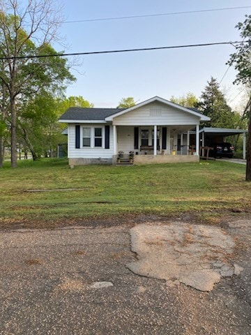 view of front of property featuring driveway, a carport, and a front lawn