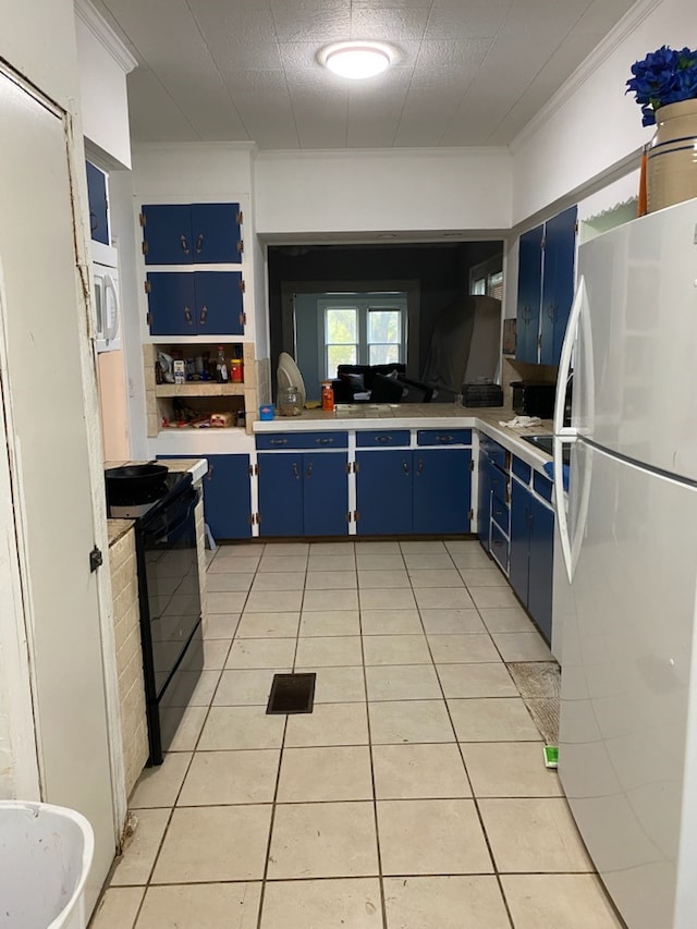 kitchen featuring blue cabinetry, light tile patterned floors, light countertops, and white appliances