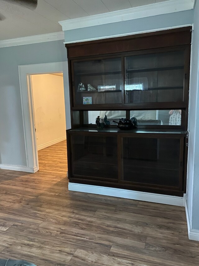 details featuring crown molding, baseboards, and wood finished floors