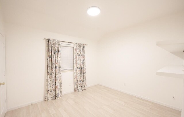 8729 Shavano Dr, Fort Worth, TX 76123 - empty room featuring wood finished floors, vaulted ceiling, and baseboards