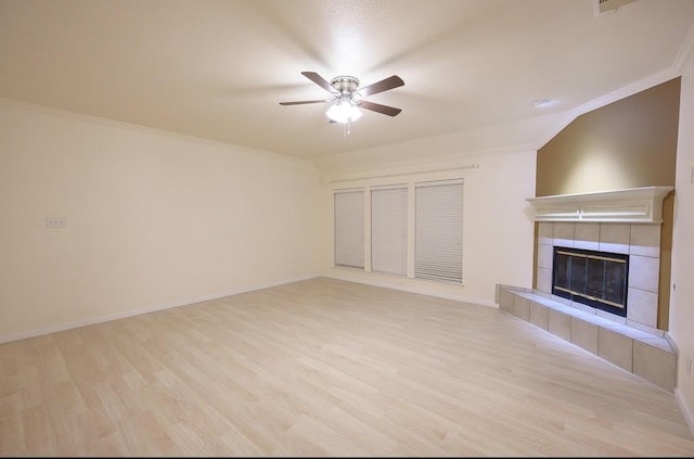 8729 Shavano Dr, Fort Worth, TX 76123 - unfurnished living room with a ceiling fan, wood finished floors, a tiled fireplace, crown molding, and baseboards