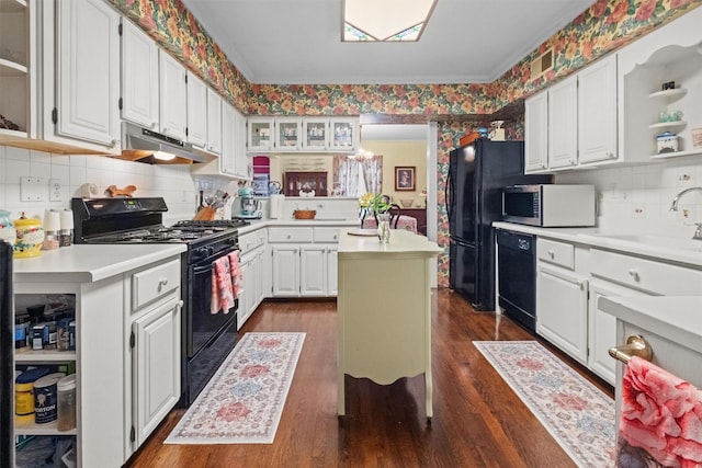 kitchen featuring open shelves, a sink, light countertops, under cabinet range hood, and black appliances