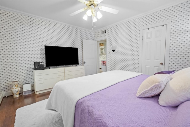 bedroom with wallpapered walls, visible vents, ornamental molding, and wood finished floors