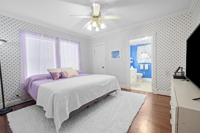 bedroom with wallpapered walls, ensuite bath, crown molding, ceiling fan, and wood finished floors