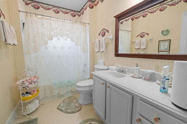 bathroom featuring toilet, vanity, and wallpapered walls