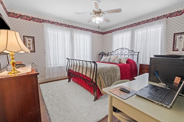 bedroom featuring ceiling fan, wallpapered walls, and wood finished floors
