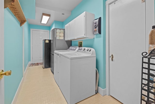 washroom with baseboards, washing machine and clothes dryer, and cabinet space