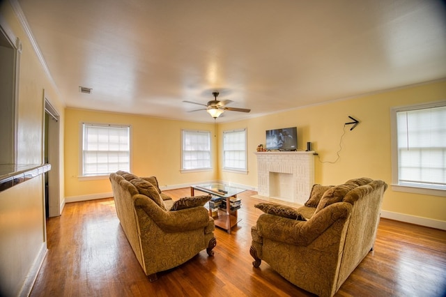 living area featuring a healthy amount of sunlight, baseboards, a ceiling fan, and visible vents