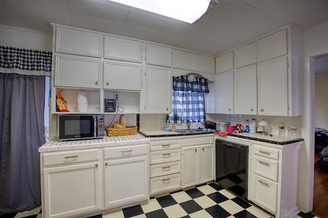kitchen featuring tile counters, backsplash, black appliances, and light floors