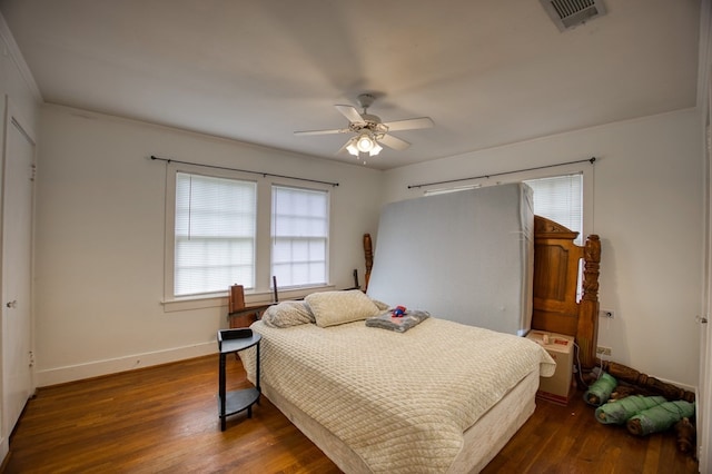 bedroom with visible vents, baseboards, a ceiling fan, and wood finished floors