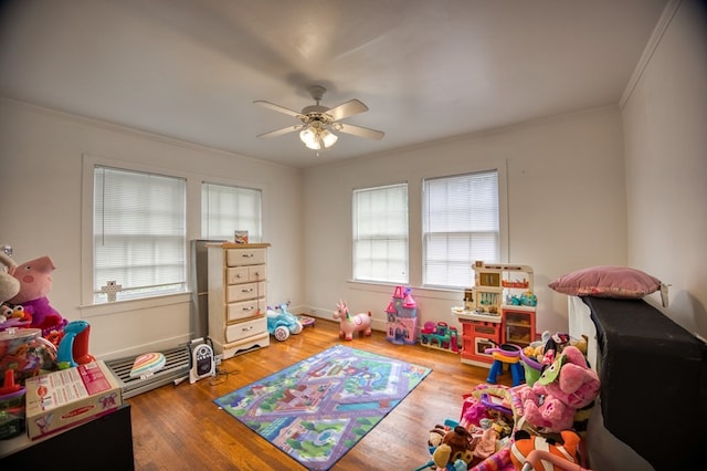 rec room featuring crown molding, wood finished floors, and a ceiling fan