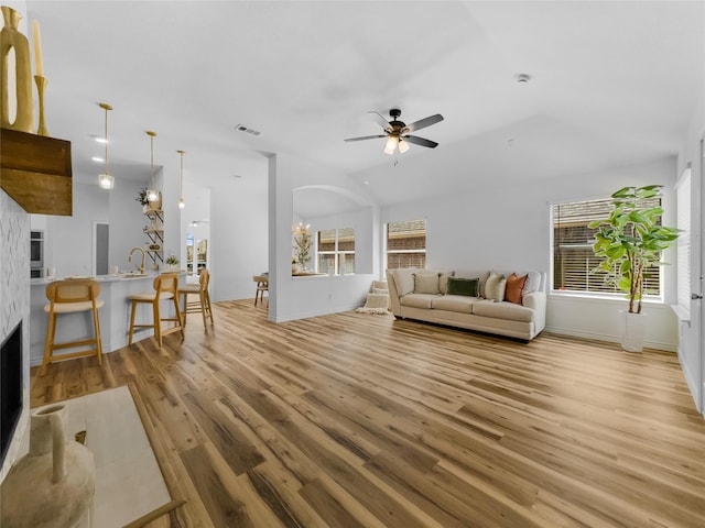 4512 Stepping Stone Dr, Fort Worth, TX 76123 - living area with a fireplace, light wood-style flooring, baseboards, visible vents, and ceiling fan