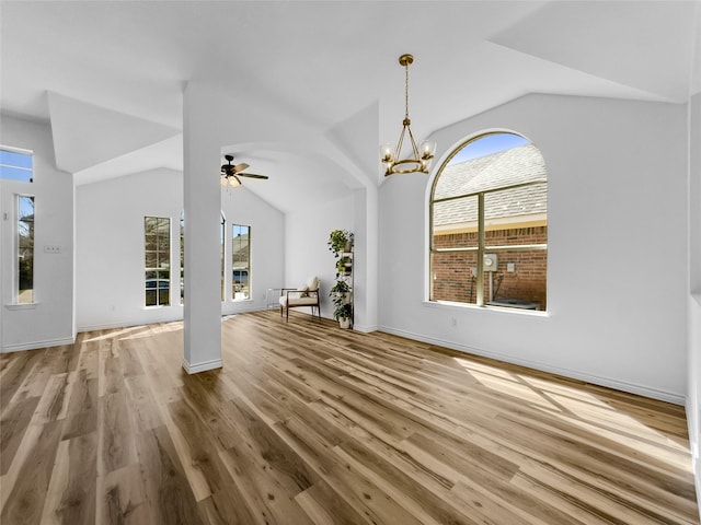4512 Stepping Stone Dr, Fort Worth, TX 76123 - unfurnished living room with ceiling fan with notable chandelier, vaulted ceiling, wood finished floors, and baseboards