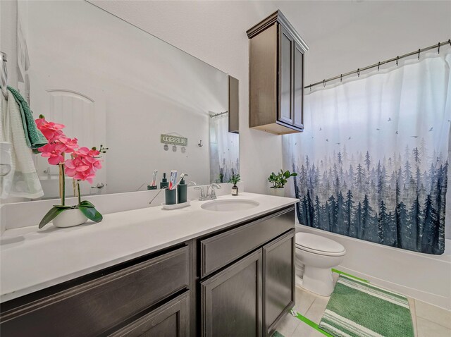 bathroom featuring toilet, tile patterned flooring, vanity, and shower / bath combo with shower curtain