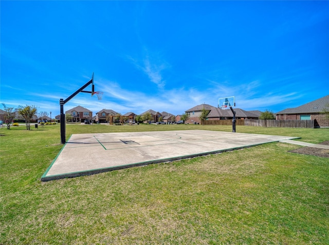 view of sport court with a residential view, community basketball court, fence, and a lawn