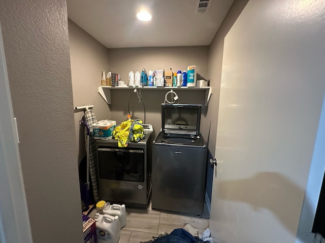 laundry area featuring independent washer and dryer, visible vents, and laundry area