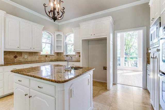 4908 Meandering Way, Colleyville, TX 76034 - kitchen with a sink, dark stone countertops, a chandelier, an island with sink, and white cabinets