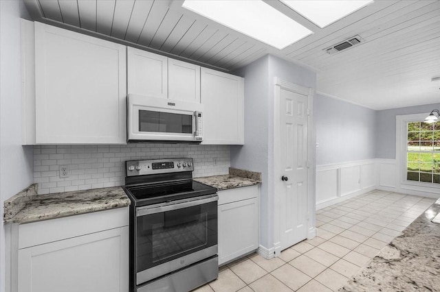 120 Southwinds Dr, Weatherford, TX 76087 - kitchen with stainless steel electric range oven, visible vents, white microwave, white cabinetry, and light tile patterned flooring