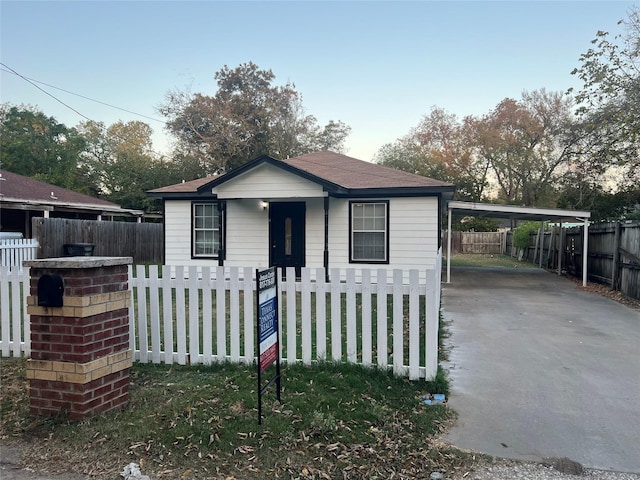 312 N Wood St, Cleburne, TX 76033 - bungalow featuring a carport, driveway, and a fenced front yard