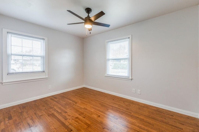 1312 Greenwood Dr, Garland, TX 75041 - unfurnished room with baseboards, wood finished floors, a healthy amount of sunlight, and a ceiling fan