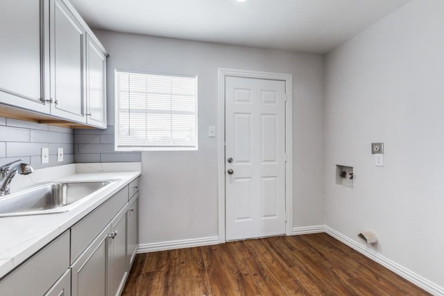 1312 Greenwood Dr, Garland, TX 75041 - laundry area featuring a sink, baseboards, cabinet space, dark wood-type flooring, and hookup for a washing machine