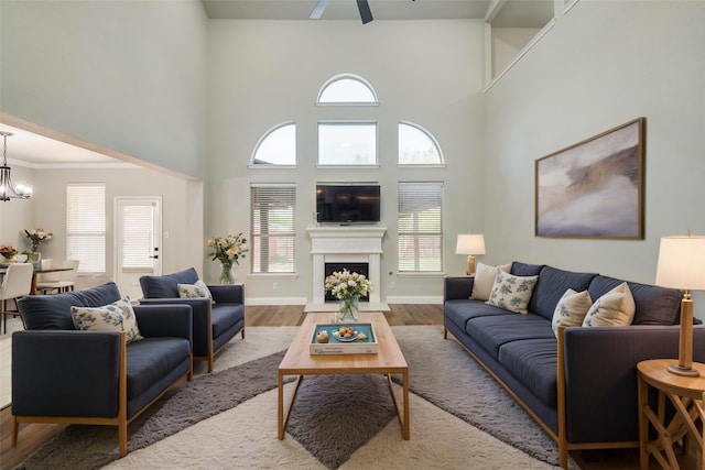 10 Monticello Ct, Mansfield, TX 76063 - living area featuring a chandelier, a fireplace, wood finished floors, healthy amount of natural light, and a high ceiling