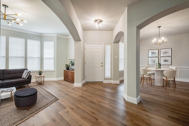 10 Monticello Ct, Mansfield, TX 76063 - foyer entrance with a chandelier, arched walkways, hardwood / wood-style floors, baseboards, and ornamental molding