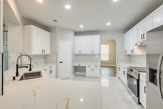 10 Monticello Ct, Mansfield, TX 76063 - kitchen with stainless steel appliances, a sink, under cabinet range hood, arched walkways, and recessed lighting