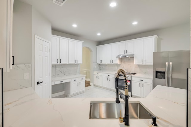 10 Monticello Ct, Mansfield, TX 76063 - kitchen featuring appliances with stainless steel finishes, arched walkways, light marble finish flooring, recessed lighting, and white cabinets