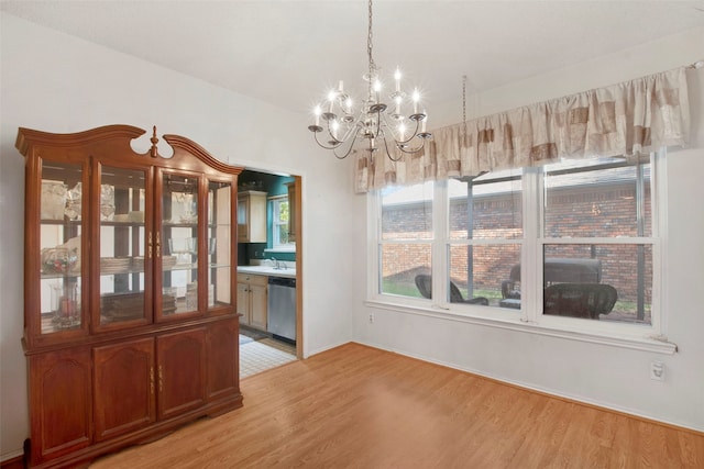 241 Tanbark Cir, Coppell, TX 75019 - unfurnished dining area with a chandelier, light wood-type flooring, and a sink