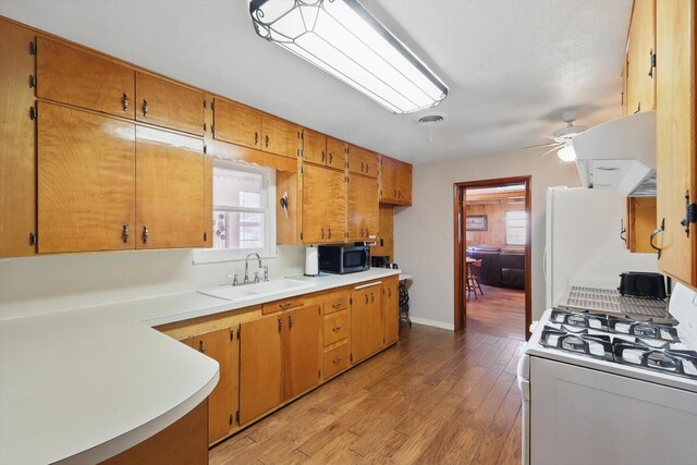 1509 Tinker Rd, Colleyville, TX 76034 - kitchen with light wood finished floors, stainless steel microwave, a ceiling fan, a sink, and gas range gas stove
