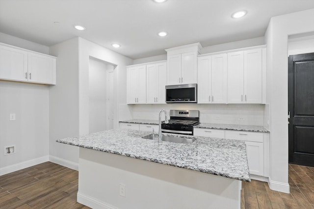 kitchen with stainless steel appliances, a sink, dark wood-style flooring, baseboards, and recessed lighting