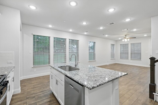 kitchen featuring a sink, stainless steel dishwasher, a ceiling fan, dark wood-style flooring, and stove
