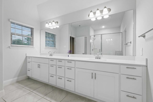 bathroom with tile patterned floors, a shower stall, double vanity, and baseboards