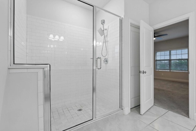 full bath with tile patterned flooring, a stall shower, ceiling fan, and baseboards