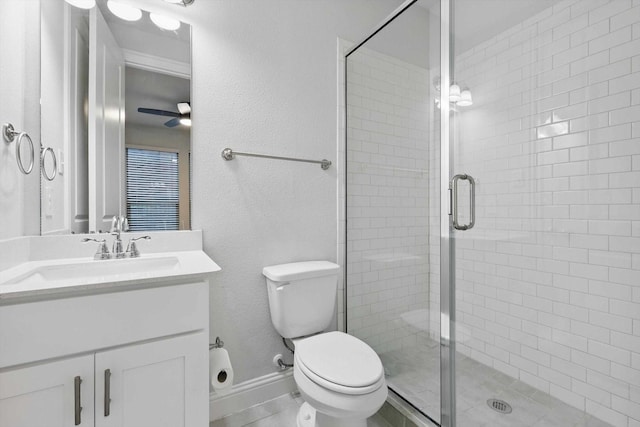 bathroom featuring a shower stall, vanity, toilet, and ceiling fan
