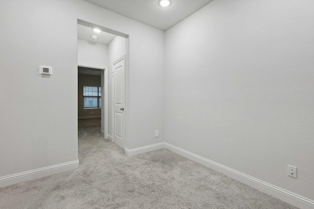 carpeted empty room featuring baseboards