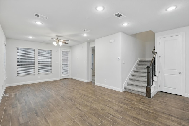 unfurnished living room featuring baseboards, stairway, a ceiling fan, wood finished floors, and recessed lighting