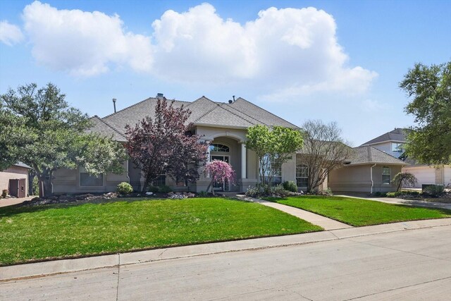 view of front of house featuring a front lawn and stucco siding