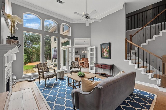 living area with crown molding, stairway, and a fireplace