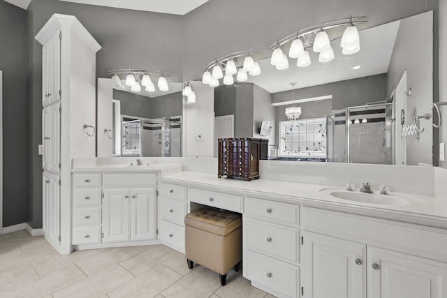 full bath with a sink, tile patterned flooring, a shower stall, and double vanity