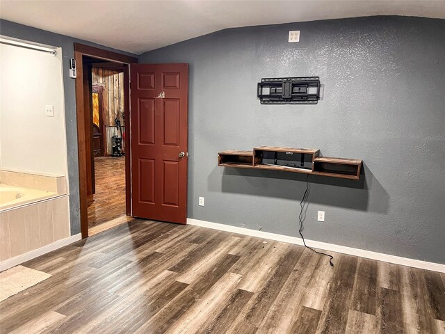 109 Bluebonnet Dr, Whitney, TX 76692 - unfurnished dining area featuring wood finished floors, baseboards, and vaulted ceiling
