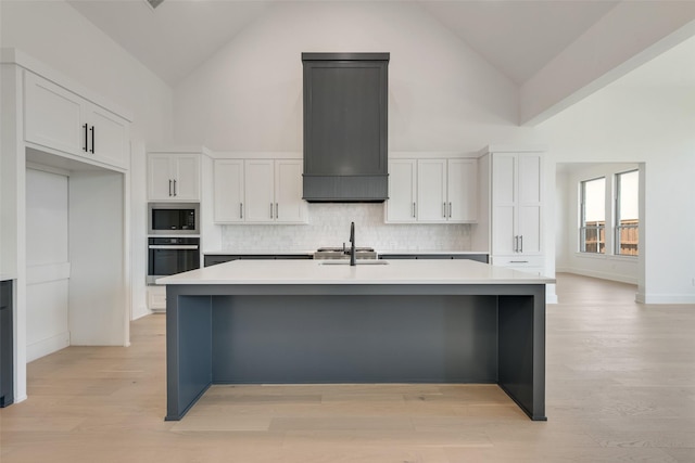 814 Montrose Dr, Rockwall, TX 75087 - kitchen with oven, high vaulted ceiling, stainless steel microwave, white cabinetry, and a kitchen island with sink