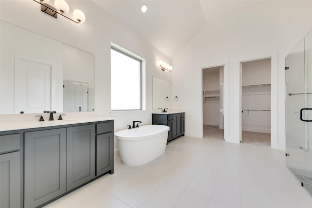 814 Montrose Dr, Rockwall, TX 75087 - full bath featuring a stall shower, vaulted ceiling, two vanities, a walk in closet, and a freestanding bath