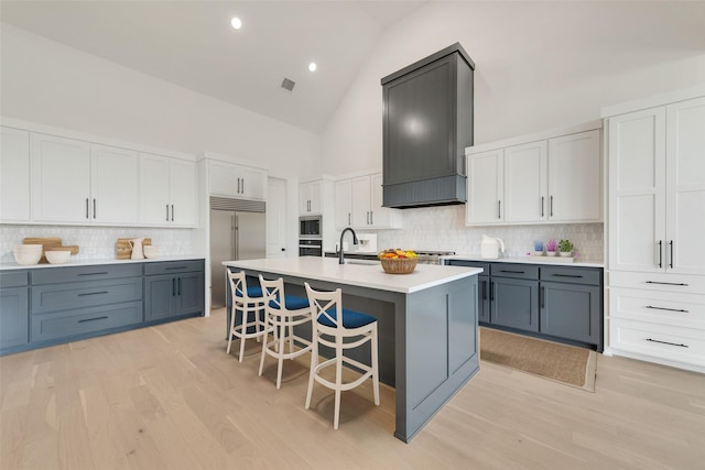 814 Montrose Dr, Rockwall, TX 75087 - kitchen with high vaulted ceiling, a kitchen bar, backsplash, built in appliances, and light countertops
