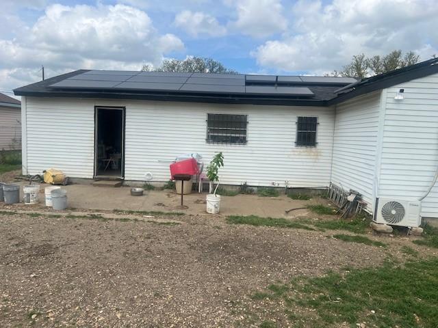 3614 Lovingood Dr, Dallas, TX 75241 - rear view of property with ac unit and roof mounted solar panels
