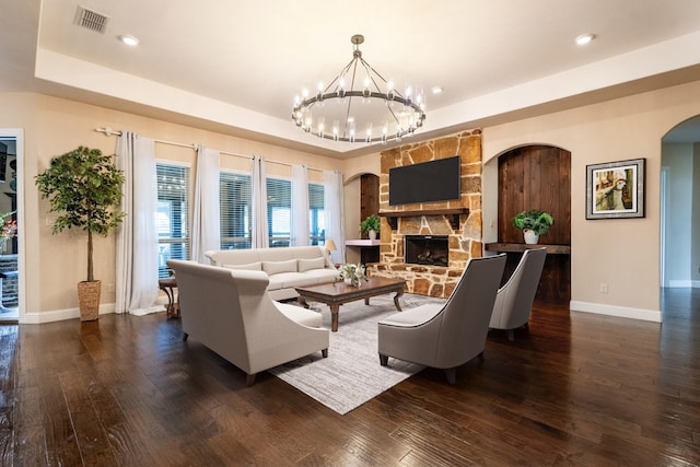 living area with dark wood finished floors, baseboards, and a raised ceiling